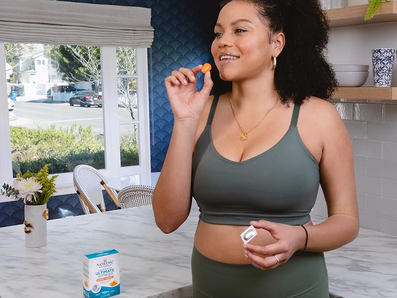 Happy human consuming a Nordic Naturals Zero Sugar Ultimate Omega Gummy Chew